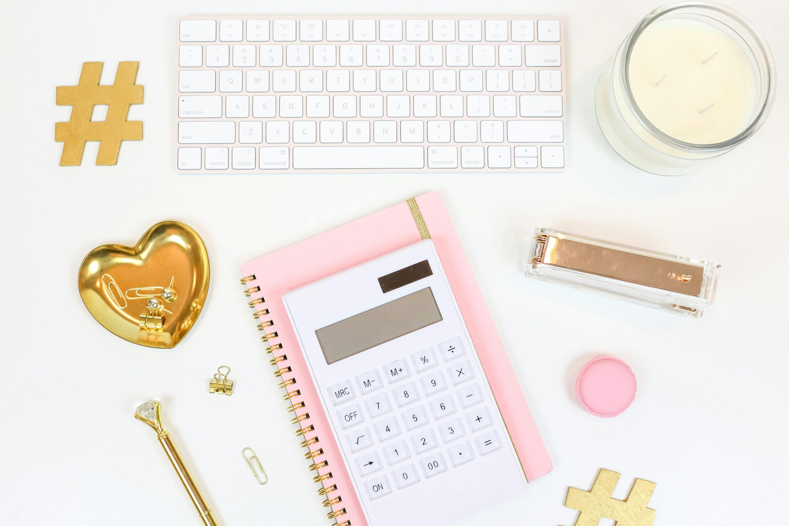 Flat lay of stylish office supplies arranged on a white background, showcasing a feminine workspace.